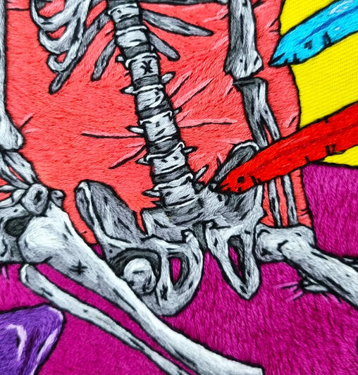 A hand embroidered skeleton torso in greyscale, leaning on a pink pillow on a fuchsia bed. there is a red sword pointing at it.